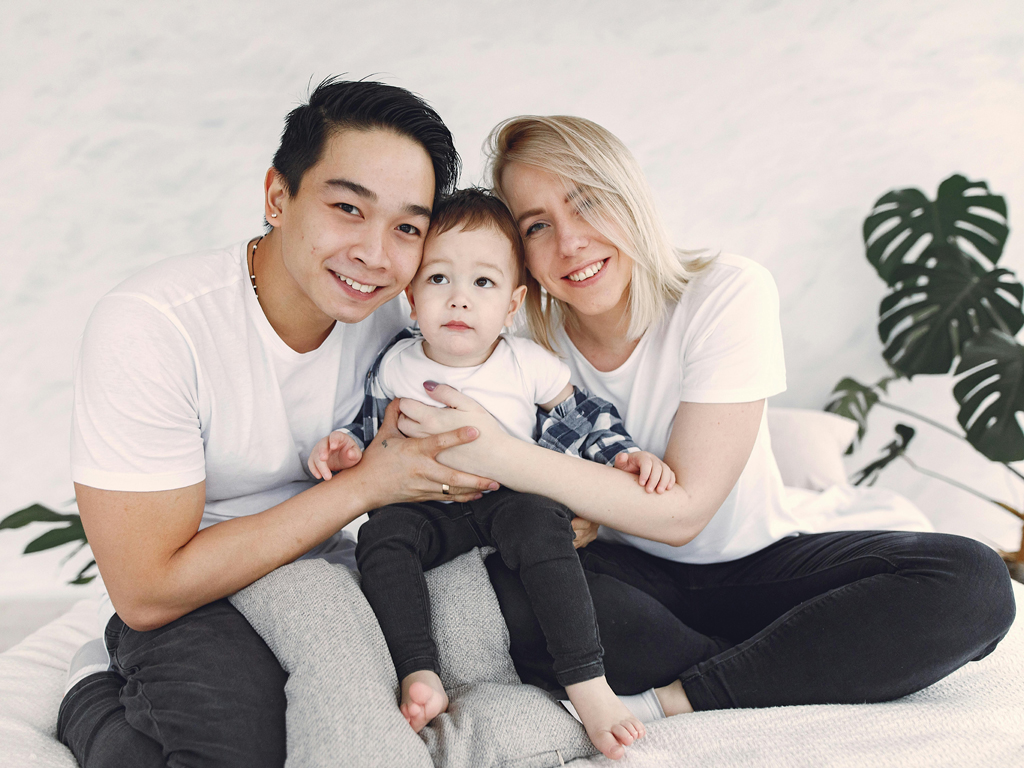 parents affectionately holding their toddler
