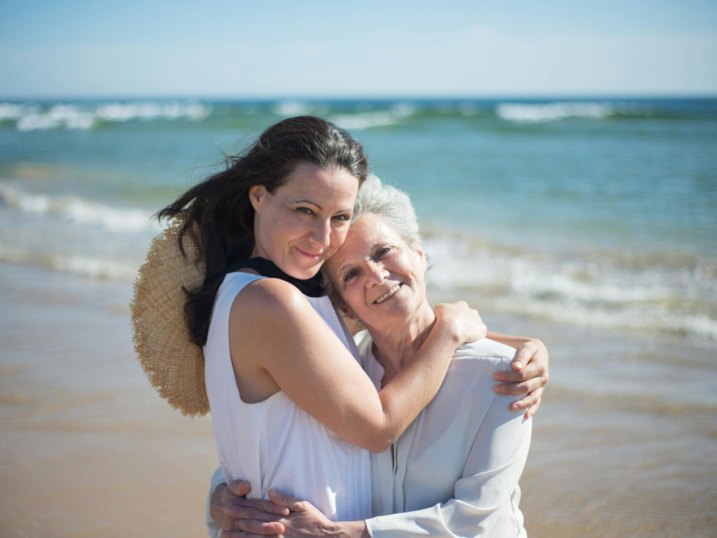 adult female hugging her elderly mom