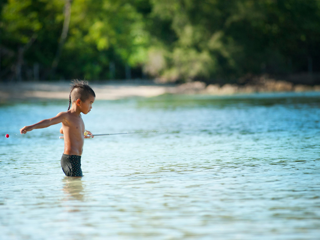 young male fishing in the water