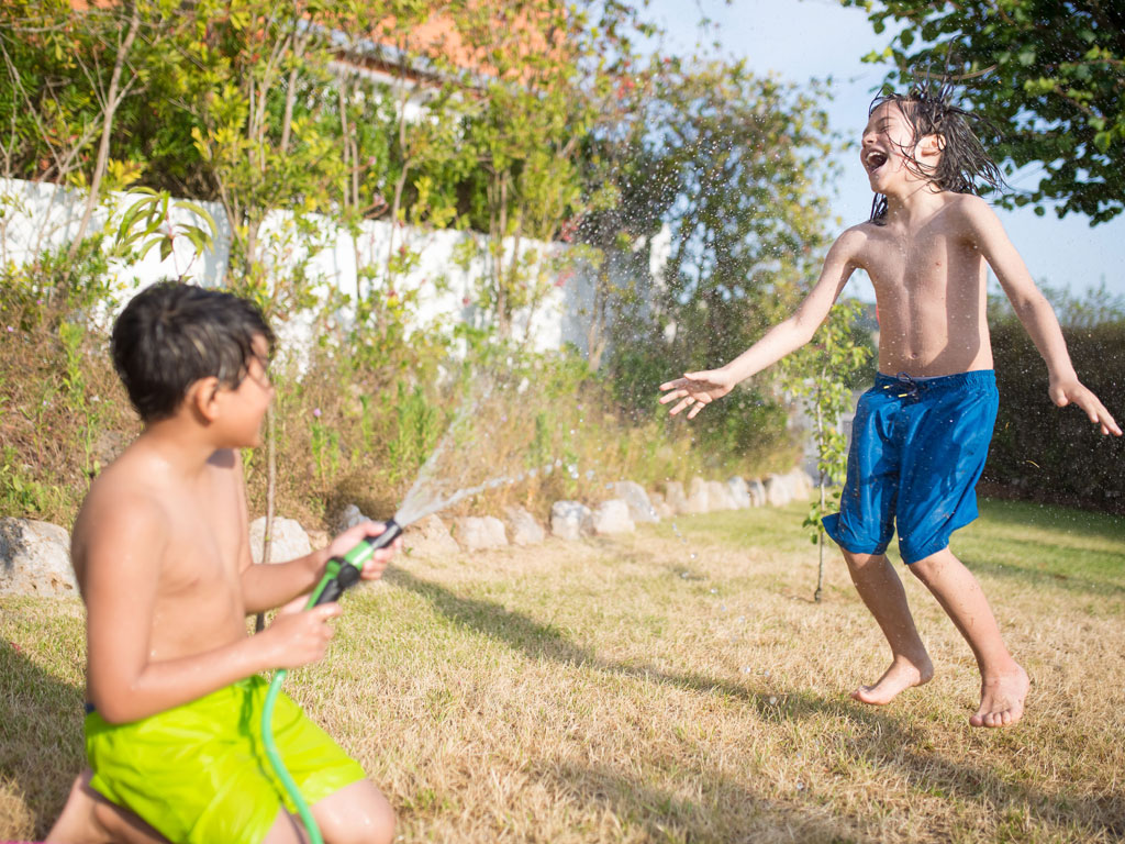 boys playing outside with water hose