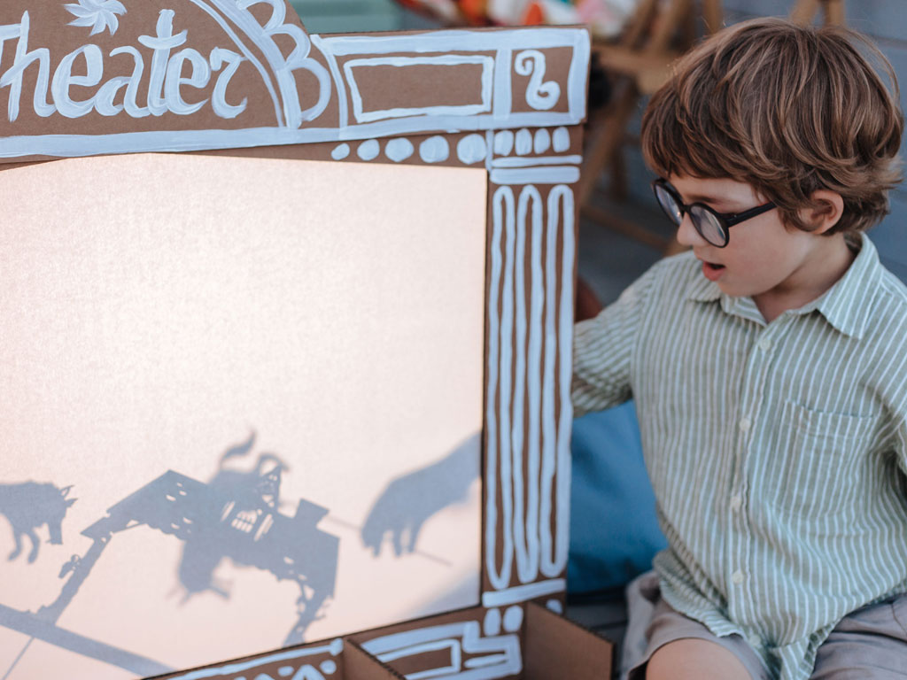 boy having fun with shadow theatre