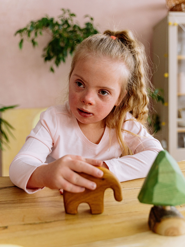 girl with down syndrome playing with wooden toys