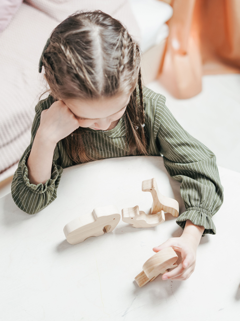 girl playing with wooden toys