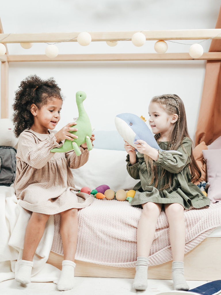 two girls playing with plush animals