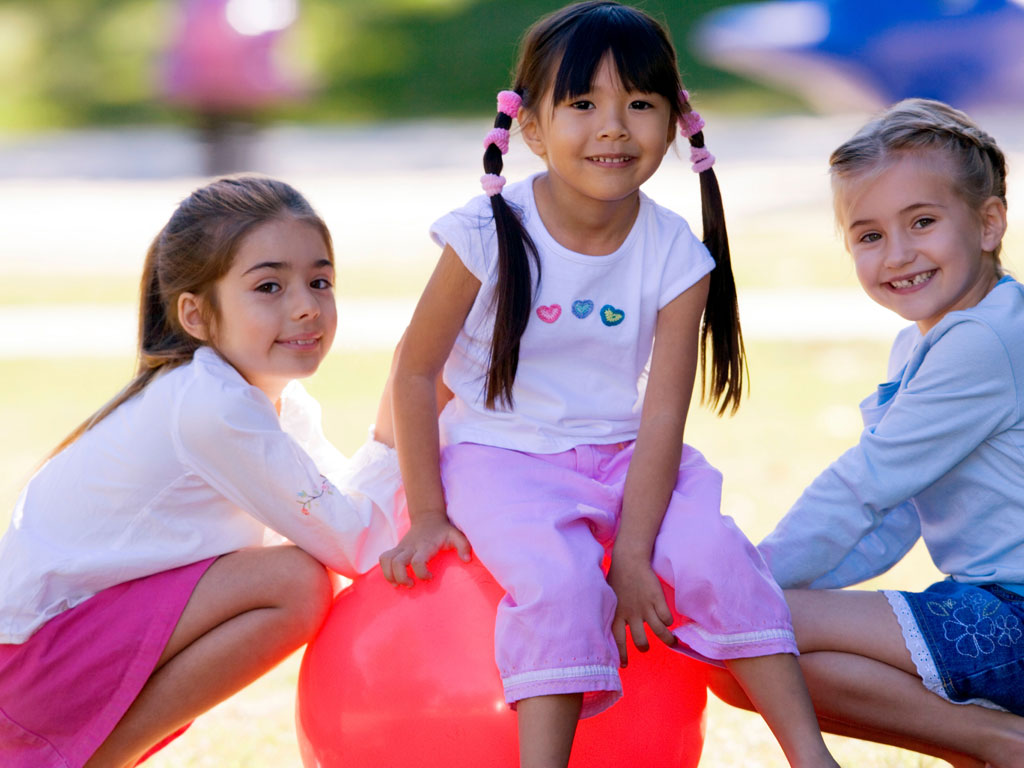 three girls smiling outdoors