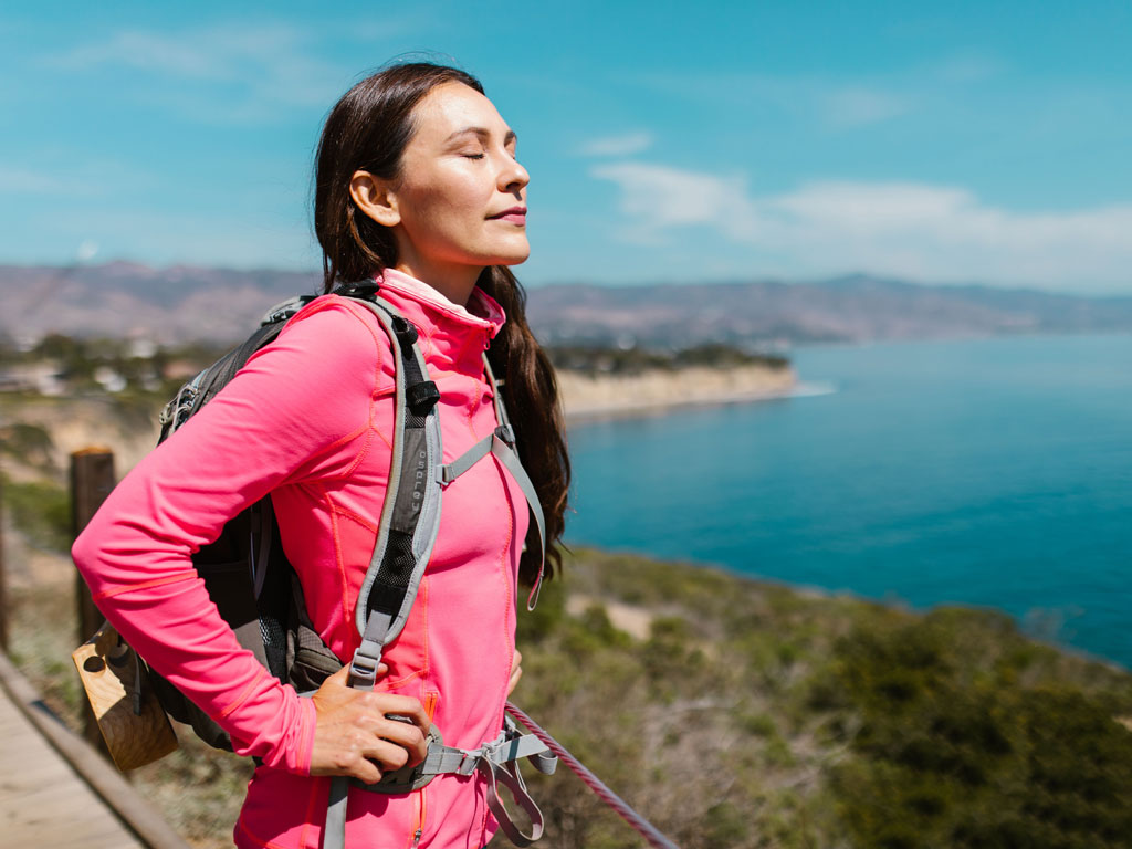 female taking a deep breath on a hike