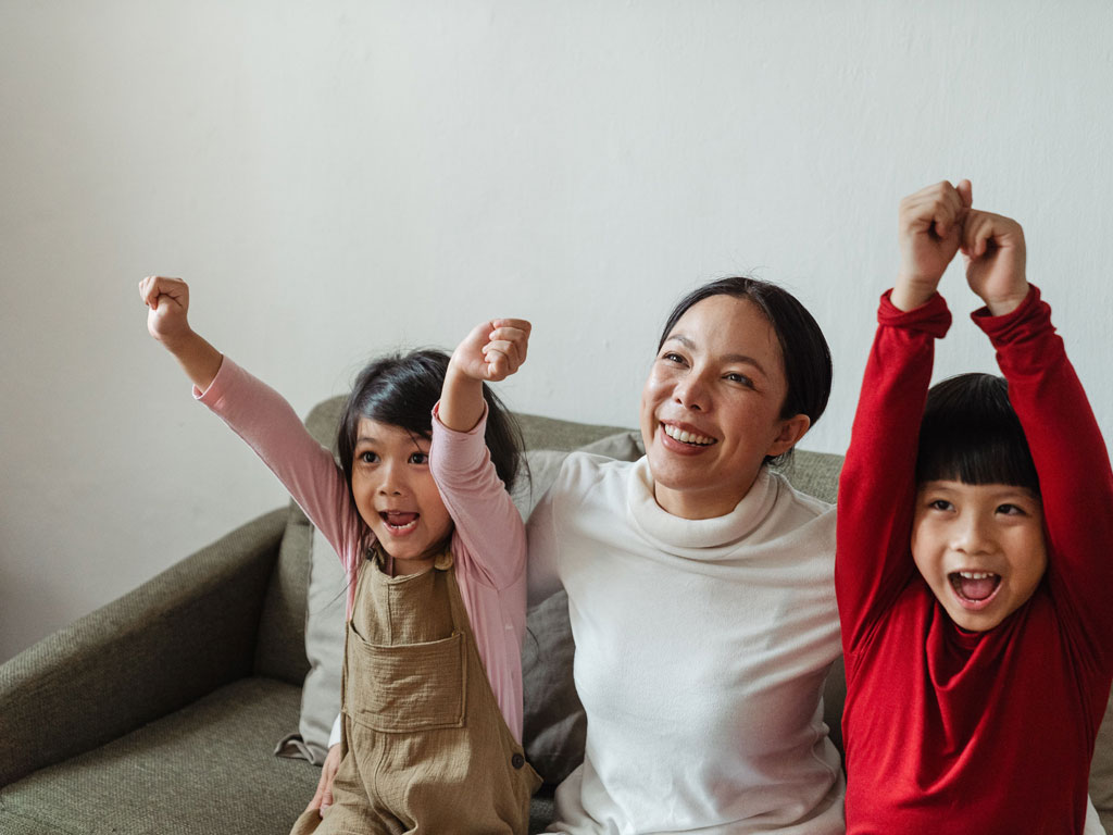 mom smiling with her young son and daughter